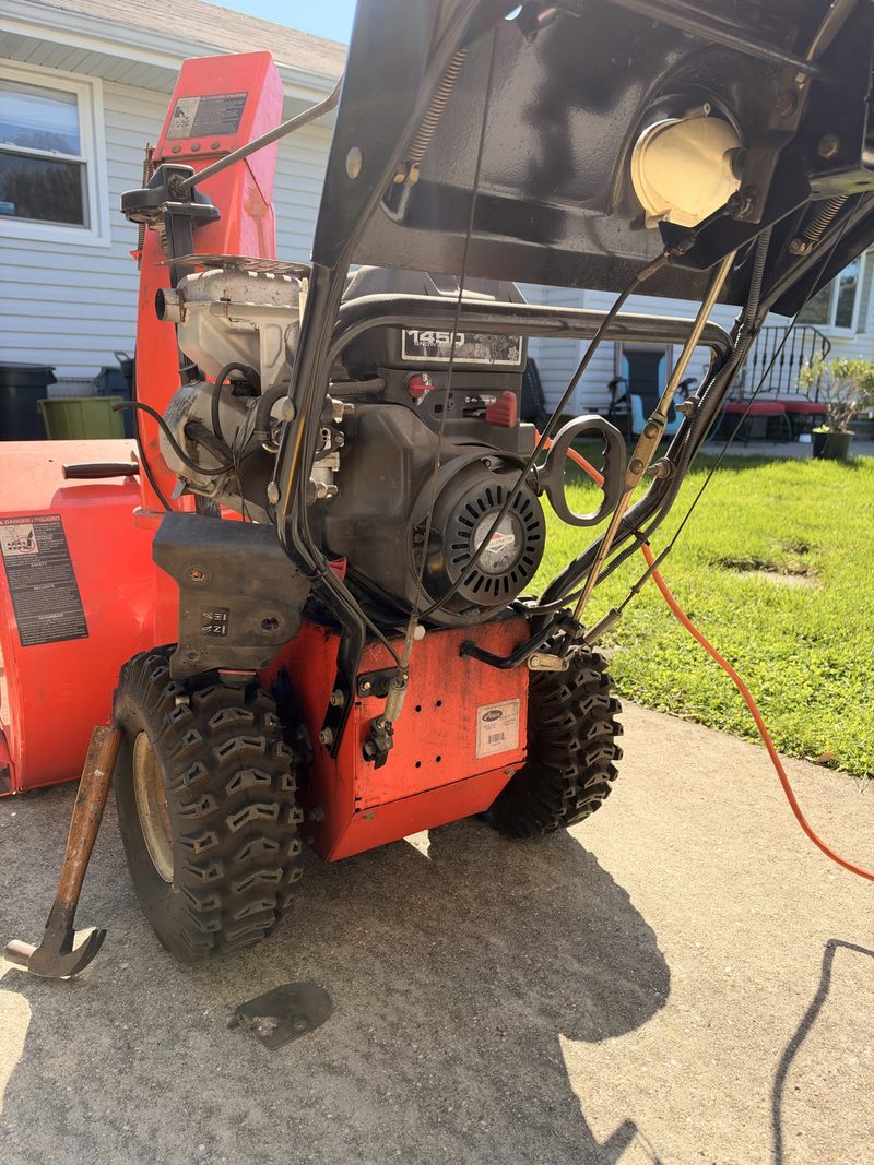 Ariens snowblower, engine view, on a driveway.